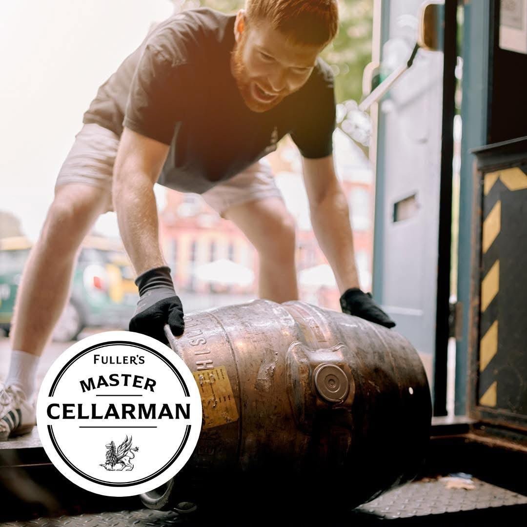 A Fuller's Master Cellarman rolling a wooden barrel into The Union Inn